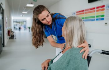 Young woman doctor taking care of senior woman at a wheelchair.