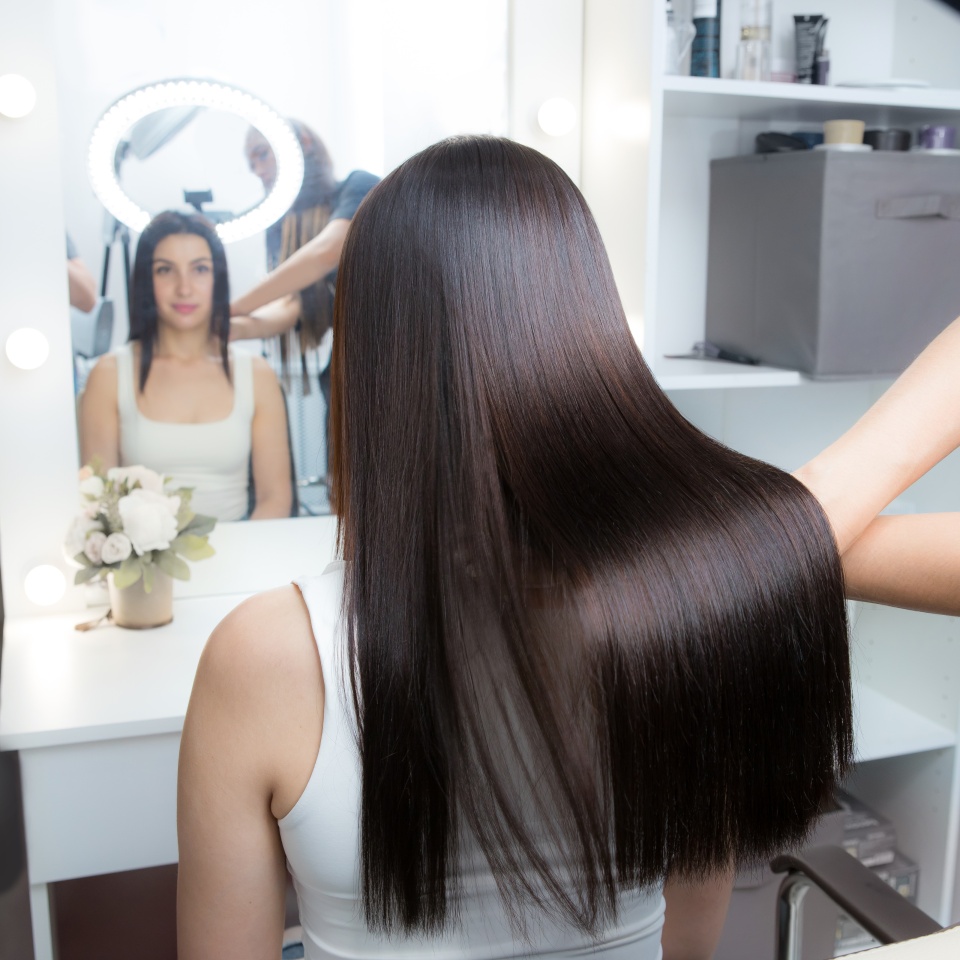 Hairdresser shows saturated healthy shiny hair after keratin recovery. The concept of recovery structure.